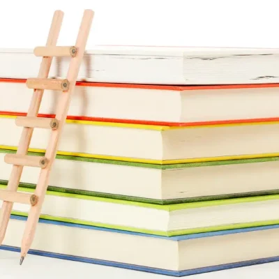 Mini-échelle à côté de six livres illustrant la progression étape par étape dans l’apprentissage de l’arabe littéraire et la compréhension du Coran.